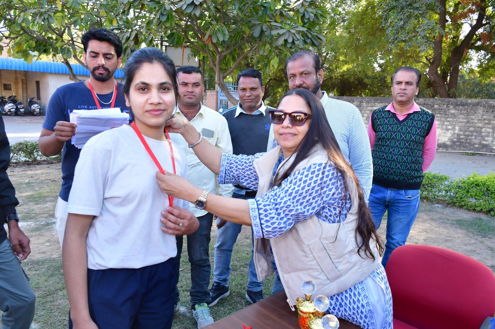 Sports day medal ceremony with students and organisers.